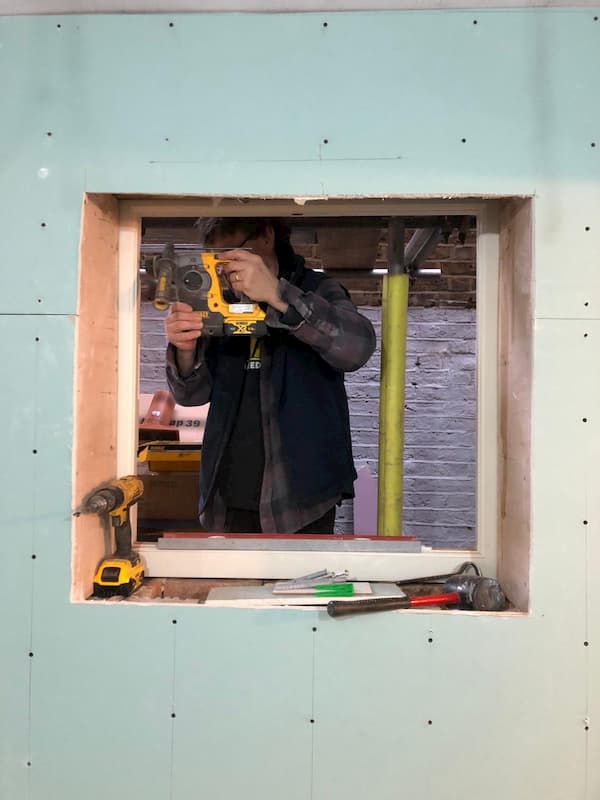 Taken from inside, shows Ian working outside on the window frame