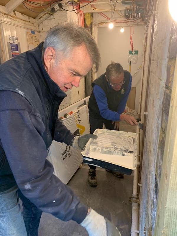 Richard and Trevor scraping down the old corridor wallsto make it good for painting