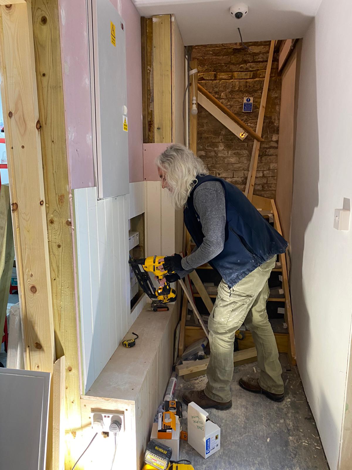 Tony cutting fireboard around the main electric panel