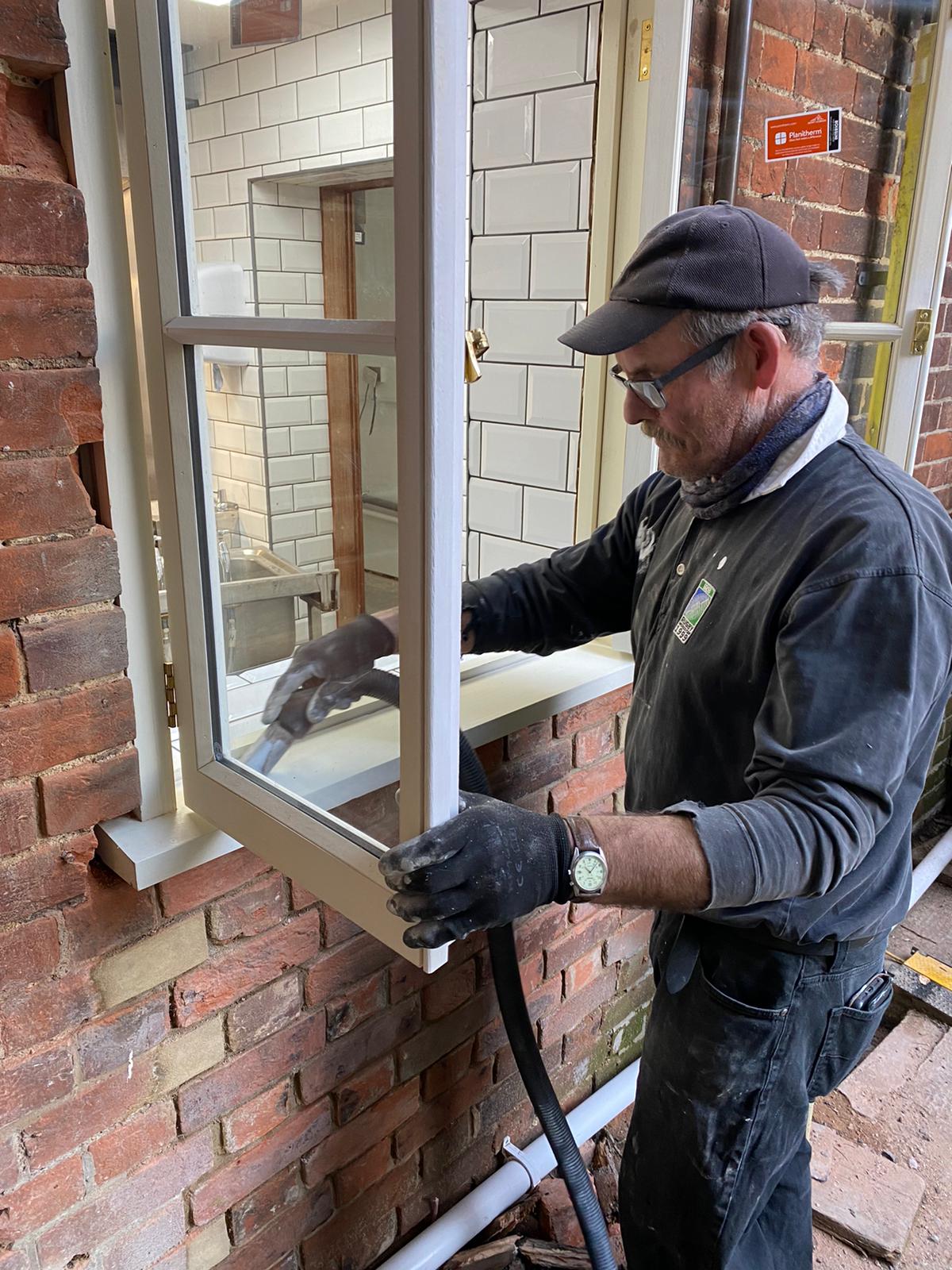 John painting one of the windows for The Kitchen