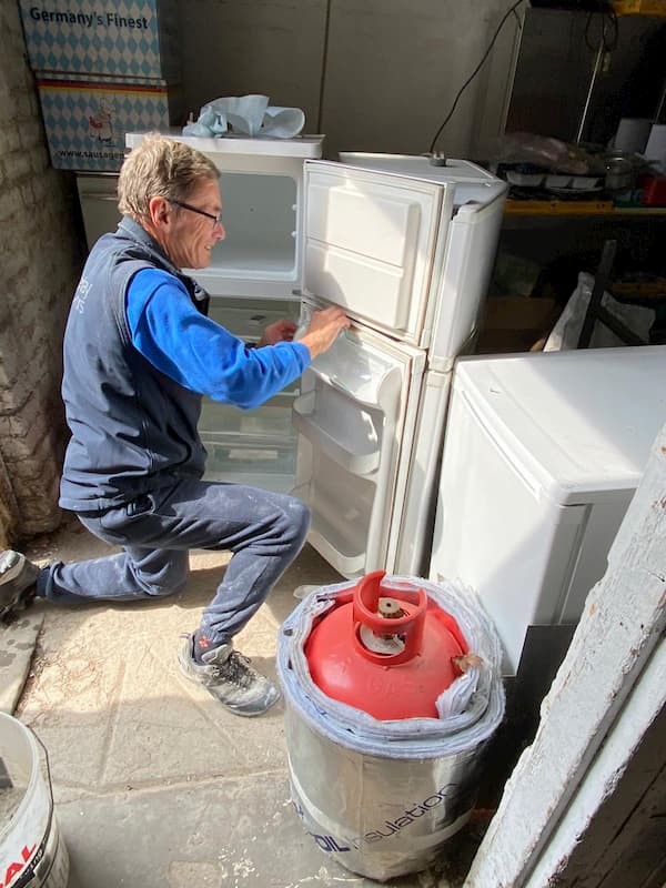 Trevor cleaning one of the fridges ready for re-charging the gas