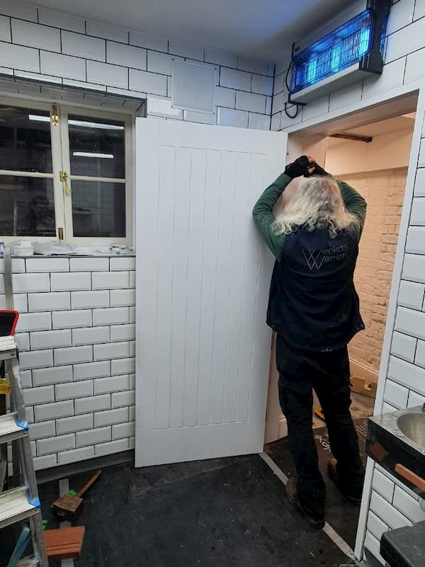 Tony working on The Kitchen door to level it.