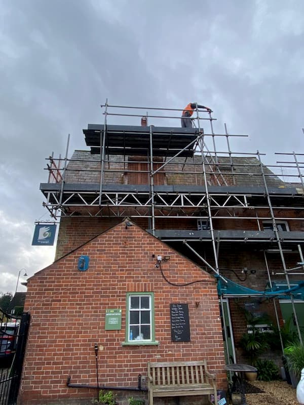 Warren at the very top of the scaffolding starting to disassemble it.