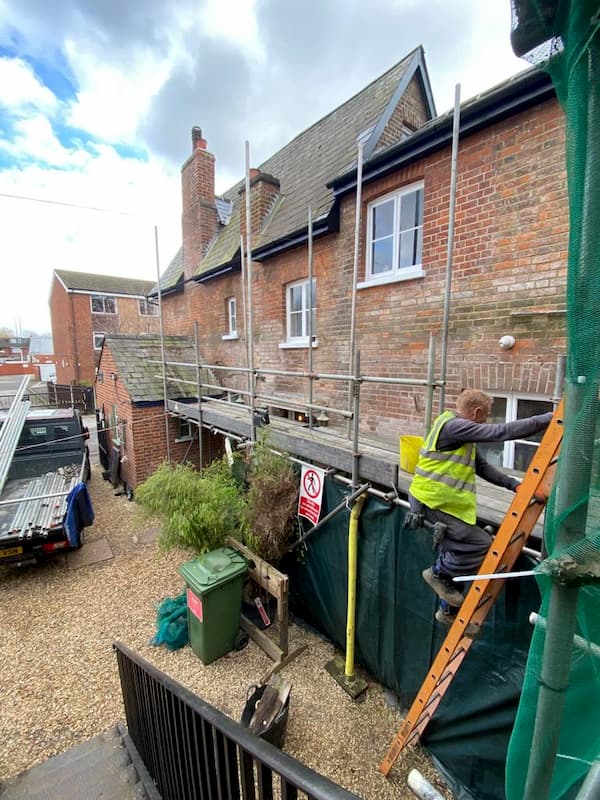 Warren coming down the ladders with a lorry with some of the scafolding poles loaded already