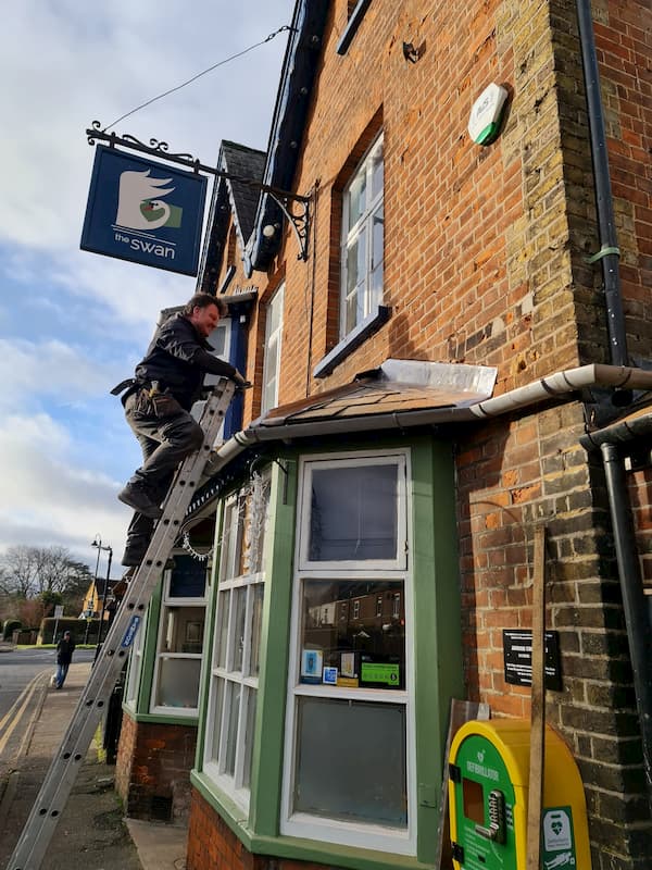 Paul working on the flashing at the front of the building over one of the bay windows.