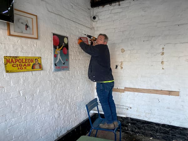 Paritally cleared underneath and traditional pub signs being attached to The Coach House underneath the covered area.