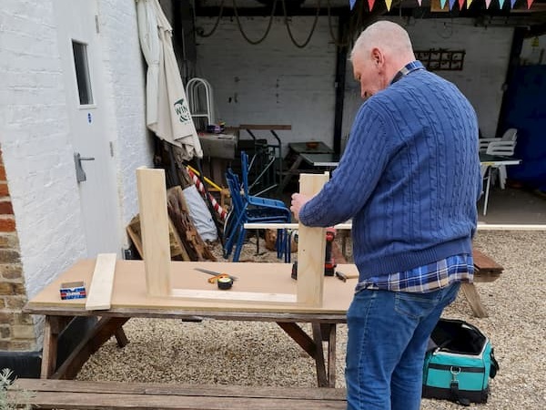 Bill cutting pieces of wood out in The Courtyard.