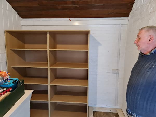 Partially assembled shelving with Bill checking it out.