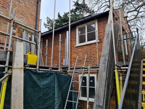 Scaffolding poles and boards stacked up ready for removal.