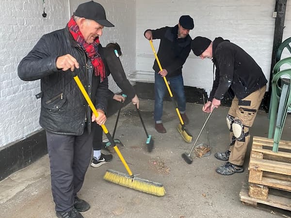 Team sweeping up underneath the covering out in The Courtyard.