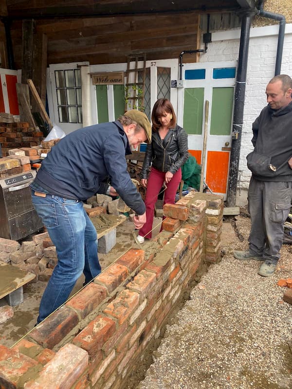 Richard Allen trying to lay some bricks.