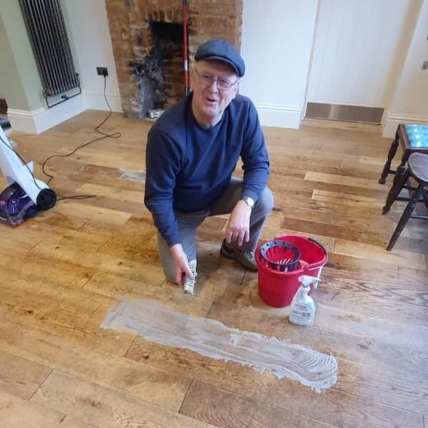 Tony on hads and knees cleaning the floor