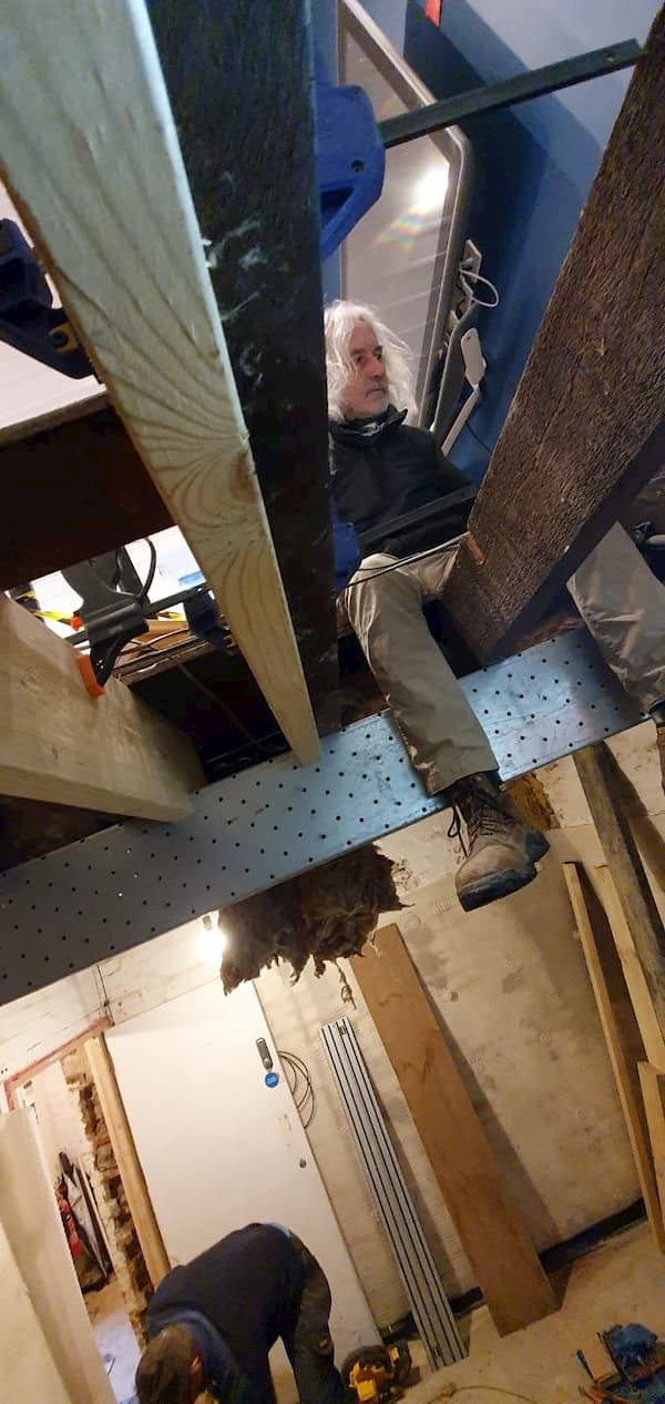 Tony working on the joists, legs dangling through the gaps