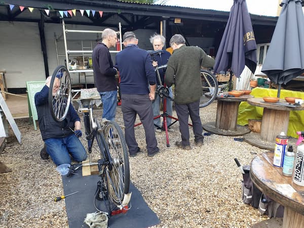 Two bikes being worked upon by a team of six trained mechanics.