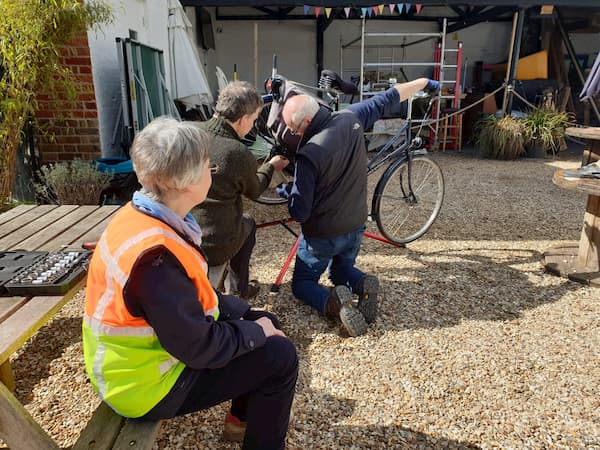 Lady watching her bike being maintained.