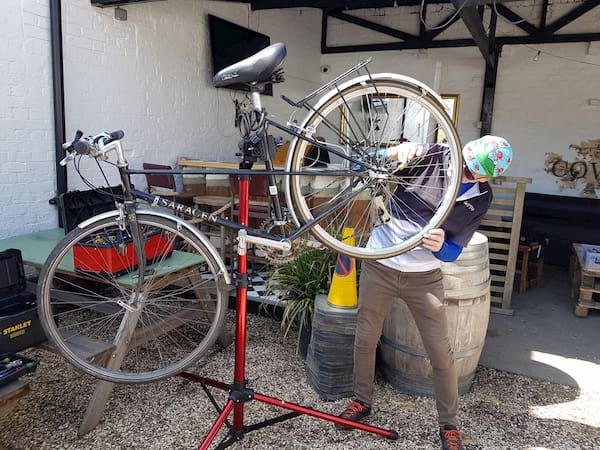 Bike up on a stand being worked on by a volunteer.