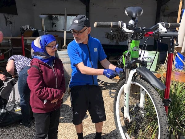 A volunteer giving some maintenance tips to a lady.